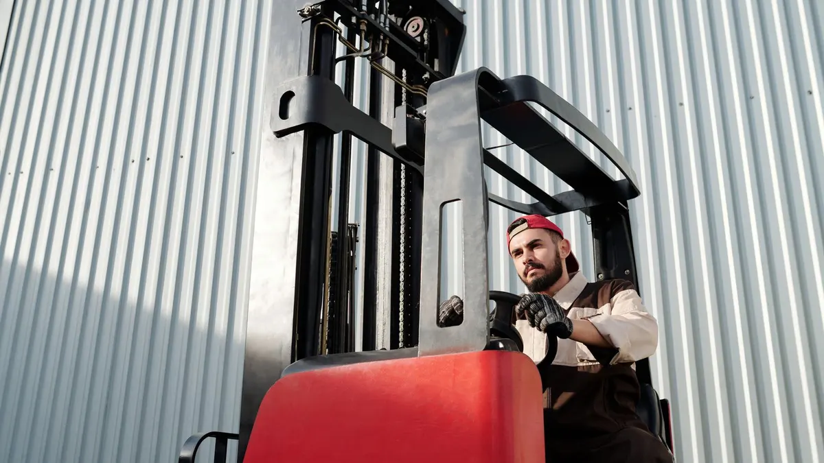 Warehouse employee operating a reach forklift outside a distribution facility